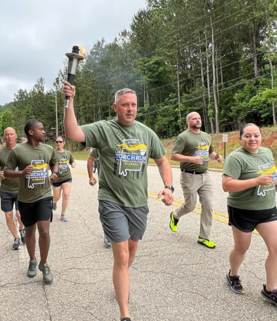 Pelham police officers are shown carrying the Flame of Hope as they run through city streets. 